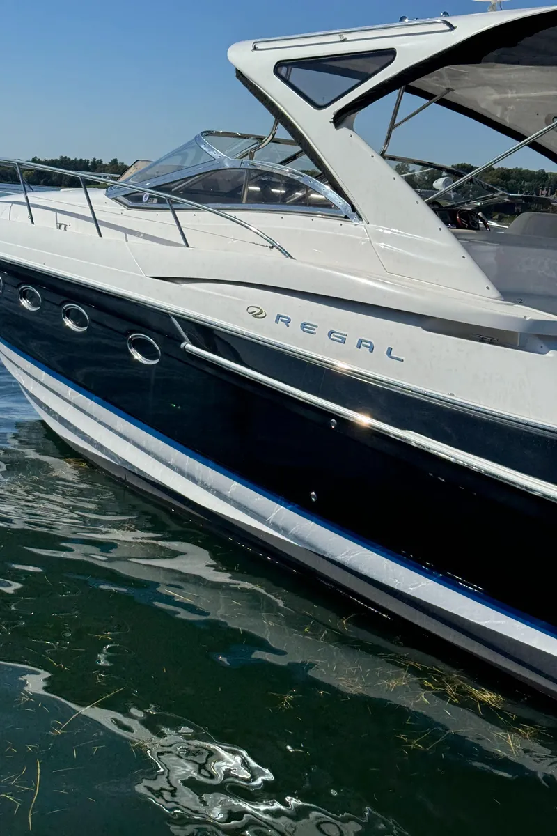 Slide: The Image of 2008 Regal Commodore 4460 yacht on water, sleek design, sunny day. - 4