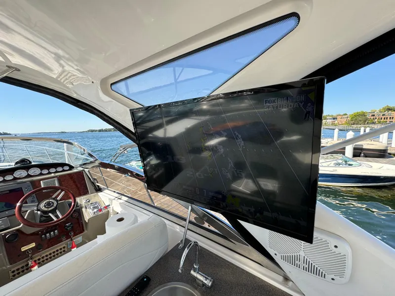 Slide: The Image of 2008 Regal Commodore 4460 yacht interior with steering wheel and mounted TV screen. - 9