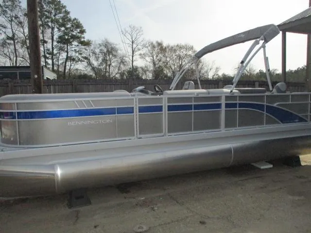 The Image of 2025 Bennington 23SXSAPG STERN FISH pontoon boat with blue accents, parked outdoors. - 1