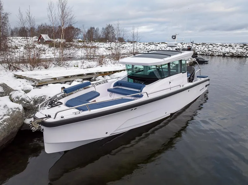 Slide: The Image of 2025 Axopar 29 Cross Cabin boat docked in snowy waterside setting. - 3