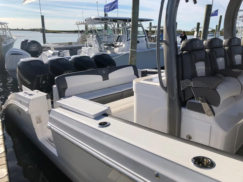 Slide: The Image of 2020 Fountain 43 NX boat docked, featuring multiple outboard engines and luxurious seating. - 2