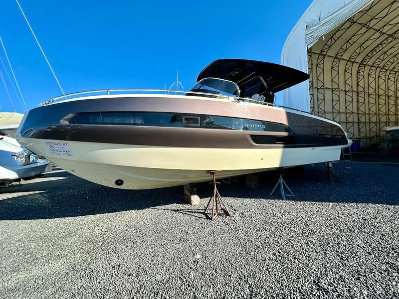 Slide: The Image of 2024 Invictus GT320S boat on display in a marina setting. - 0