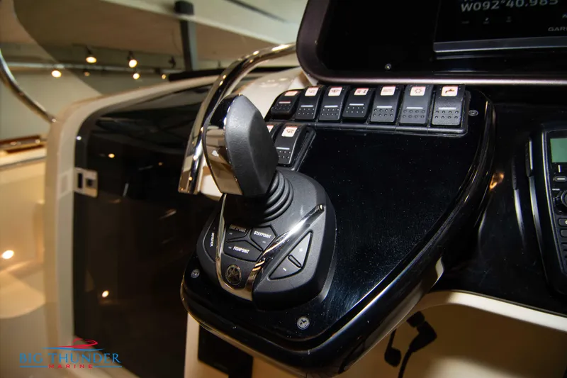 Slide: The Image of 2024 Invictus GT320S control panel with joystick and switches in a luxury boat cockpit. - 28