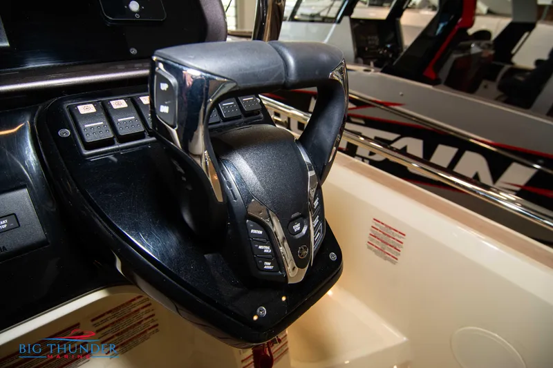 Slide: The Image of 2024 Invictus GT320S boat control panel with steering wheel and buttons. - 29