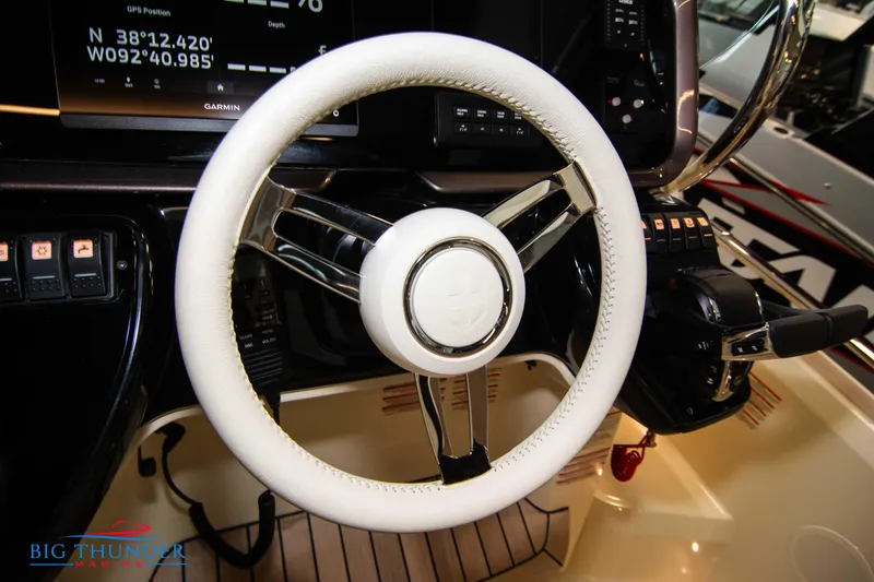 Slide: The Image of Steering wheel of 2024 Invictus GT320S boat, featuring modern controls and navigation display. - 31