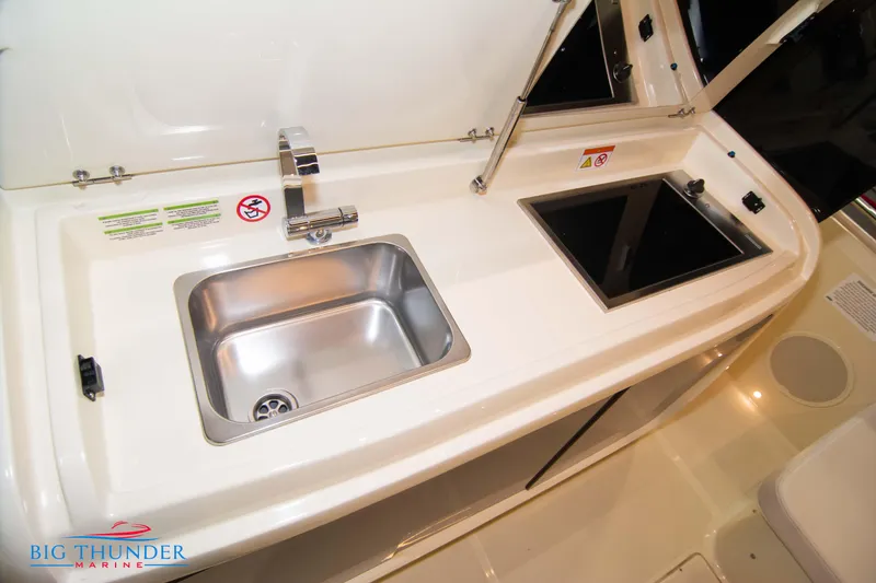 Slide: The Image of 2024 Invictus GT320S yacht kitchenette with sink and stove, featuring sleek design. - 7