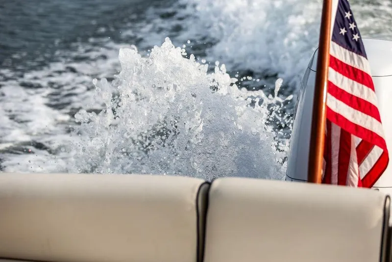 Slide: The Image of American flag on 2021 Hunt Yachts Harrier 26, with water splashing behind. - 17