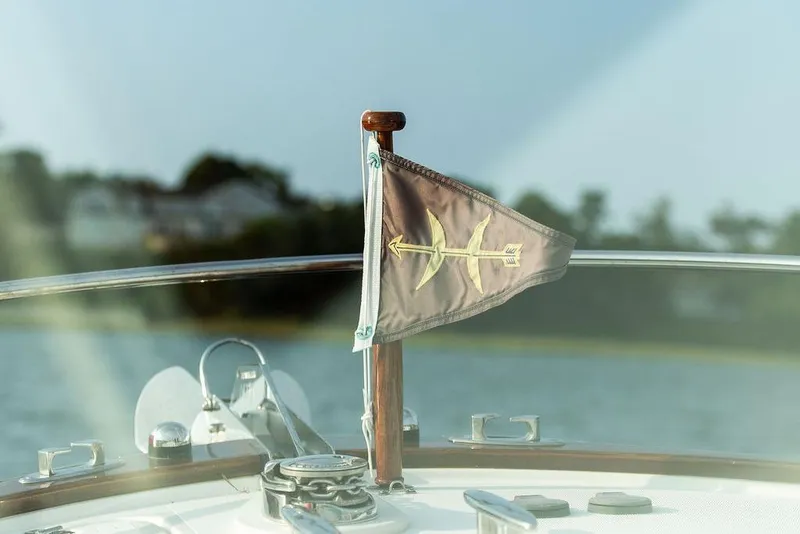Slide: The Image of 2021 Hunt Yachts Harrier 26 with flag on deck, scenic water background. - 19