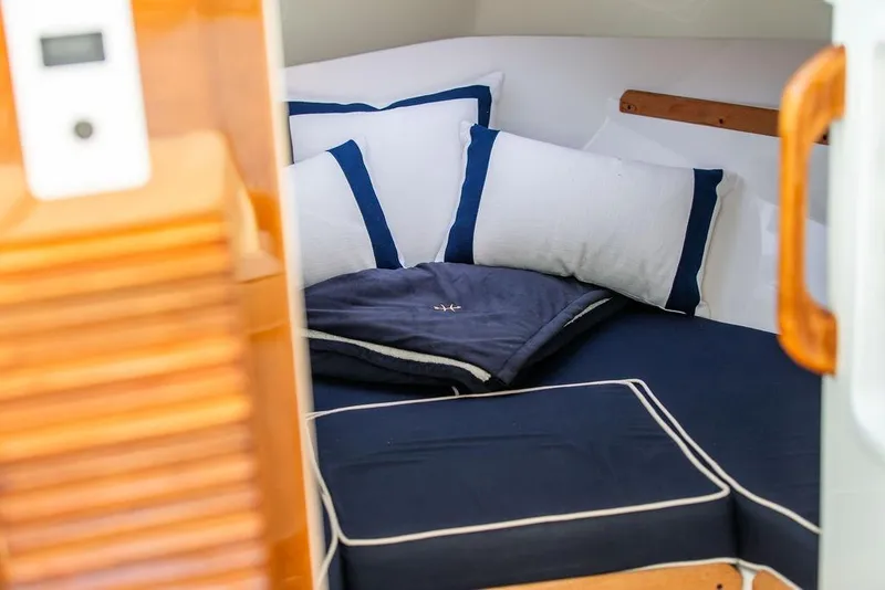 Slide: The Image of Cozy cabin interior of 2021 Hunt Yachts Harrier 26 with navy and white bedding. - 28