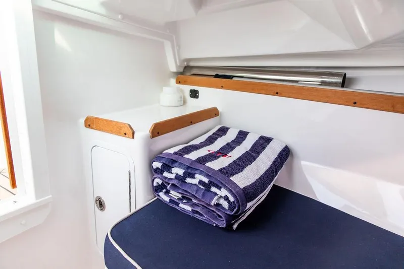 Slide: The Image of 2021 Hunt Yachts Harrier 26 interior with striped towel and seating area. - 31
