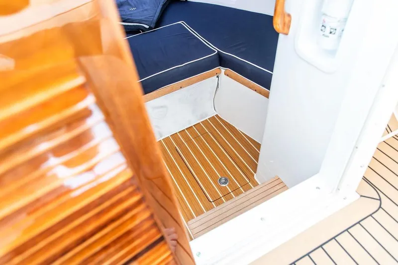 Slide: The Image of 2021 Hunt Yachts Harrier 26 interior with wooden flooring and navy seating. - 34