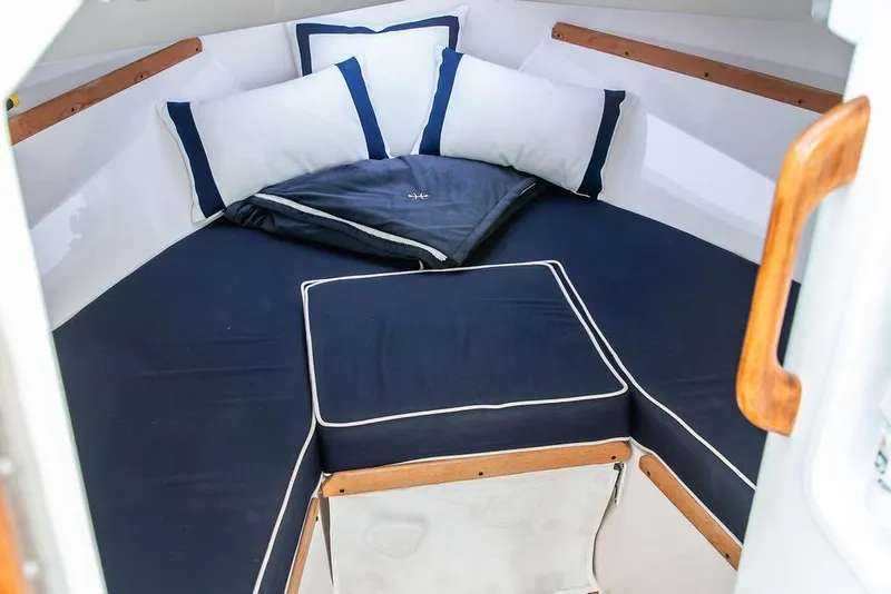 Slide: The Image of 2021 Hunt Yachts Harrier 26 cabin with navy cushions and wooden accents. - 35