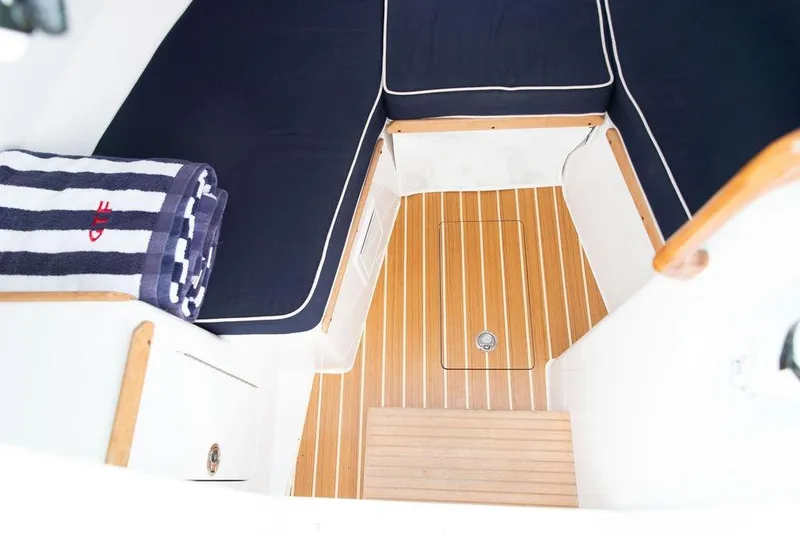 Slide: The Image of 2021 Hunt Yachts Harrier 26 interior with striped towel and wooden flooring. - 36
