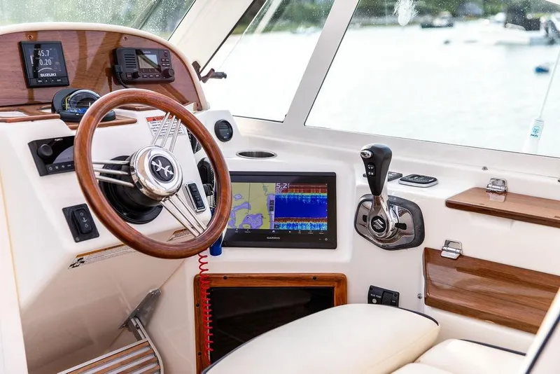 Slide: The Image of 2021 Hunt Yachts Harrier 26 helm with wooden steering wheel and modern navigation equipment. - 37