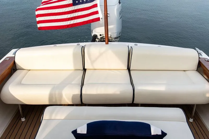 Slide: The Image of 2021 Hunt Yachts Harrier 26 with American flag, elegant seating, and outboard motor. - 38