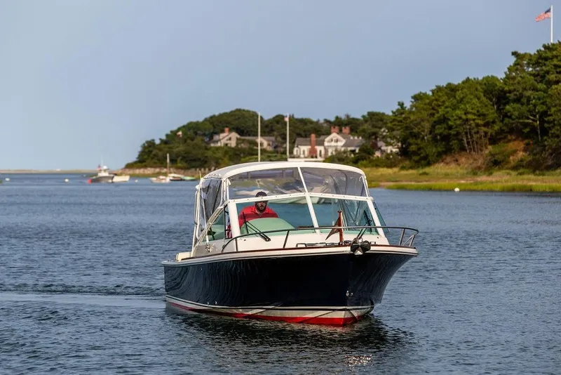 Slide: The Image of 2021 Hunt Yachts Harrier 26 cruising on a scenic waterway near a coastal village. - 51
