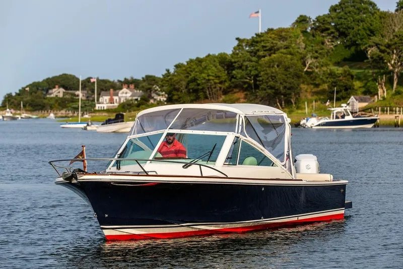 Slide: The Image of 2021 Hunt Yachts Harrier 26 cruising on a scenic waterway with lush greenery. - 52