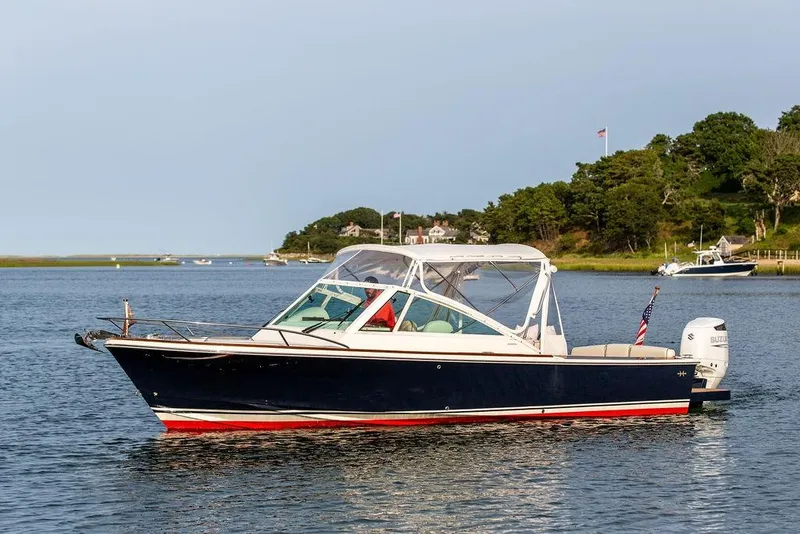 Slide: The Image of 2021 Hunt Yachts Harrier 26 cruising on a serene lake with scenic background. - 53