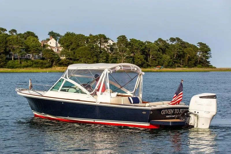 Slide: The Image of 2021 Hunt Yachts Harrier 26 on water, American flag, scenic background. - 57