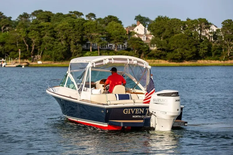 Slide: The Image of 2021 Hunt Yachts Harrier 26 cruising on a serene lake with lush greenery. - 59