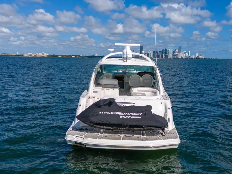 Slide: The Image of 2010 Sea Ray 500 Sundancer yacht on open water with city skyline in background. - 12