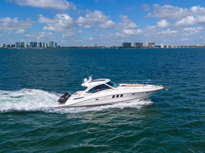 Slide: The Image of Sea Ray 500 Sundancer 2010 cruising on blue ocean with city skyline in background. - 22