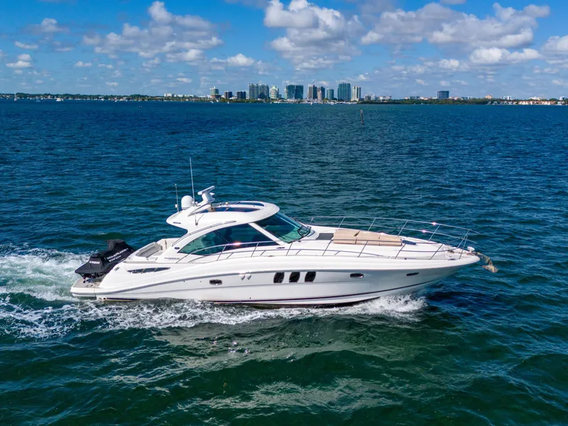Slide: The Image of 2010 Sea Ray 500 Sundancer cruising on open water under a clear blue sky. - 26