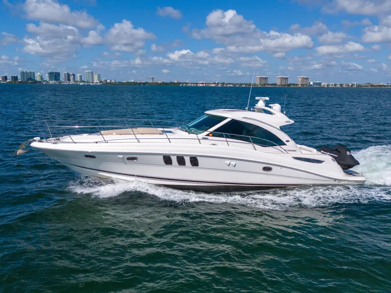 Slide: The Image of 2010 Sea Ray 500 Sundancer cruising on open water under a clear blue sky. - 29