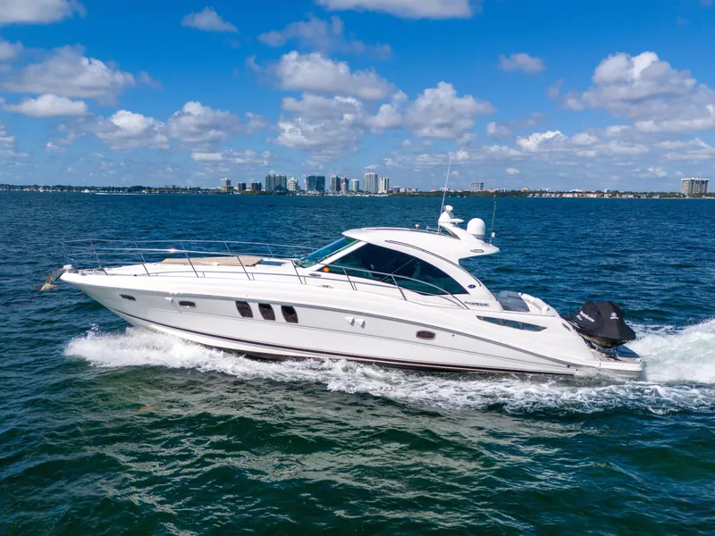 Slide: The Image of 2010 Sea Ray 500 Sundancer cruising on open water under a clear blue sky. - 6