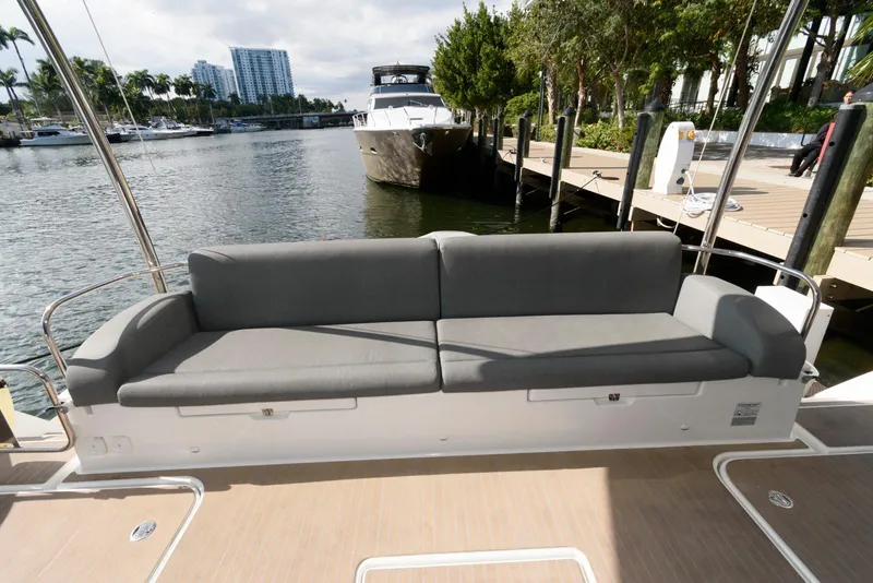 Slide: The Image of 2022 Fountaine Pajot MY6 yacht with gray seating, docked by a marina. - 10