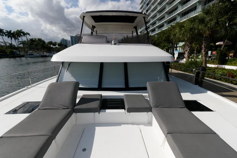 Slide: The Image of 2022 Fountaine Pajot MY6 yacht with sun loungers, docked near waterfront buildings. - 12