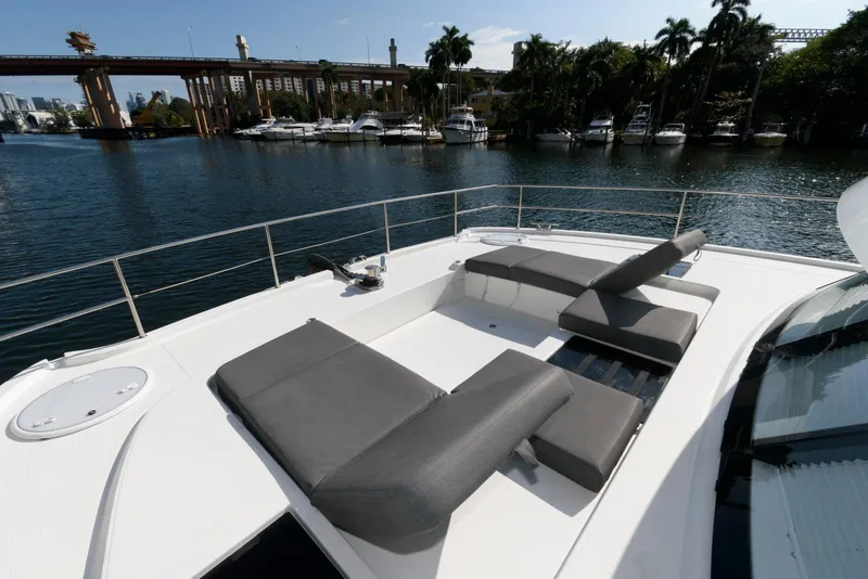 Slide: The Image of 2022 Fountaine Pajot MY6 yacht with sun loungers on deck, docked near a bridge. - 13