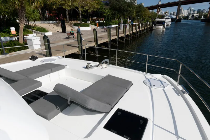 Slide: The Image of 2022 Fountaine Pajot MY6 yacht docked, featuring spacious sunbathing area with gray cushions. - 15