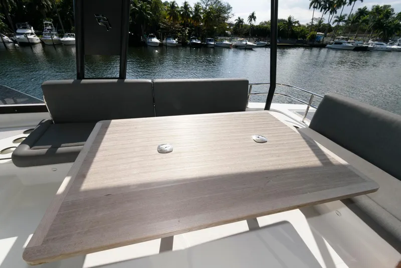 Slide: The Image of 2022 Fountaine Pajot MY6 yacht deck with seating and table, overlooking a serene waterfront. - 21
