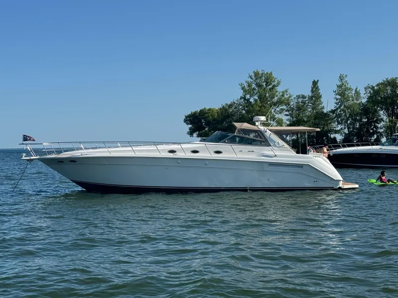 Slide: The Image of 1998 Sea Ray 500 Sundancer yacht anchored on a sunny day, surrounded by water and trees. - 0