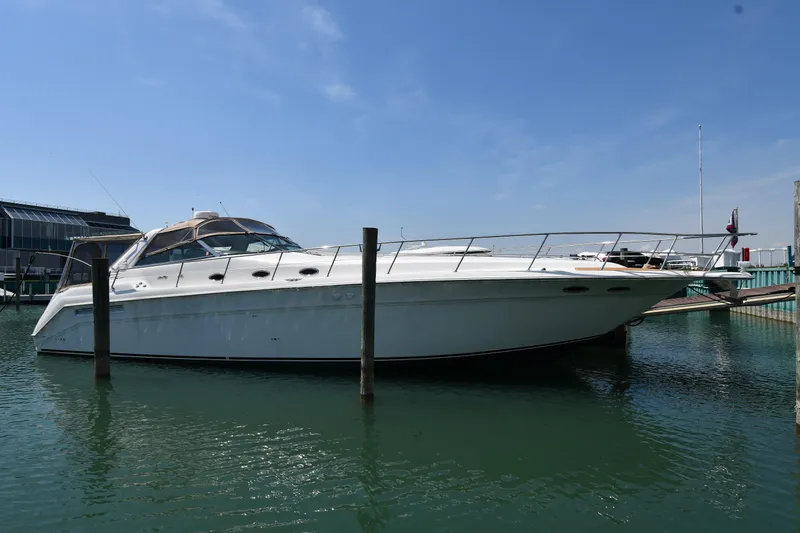 Slide: The Image of 1998 Sea Ray 500 Sundancer yacht docked in a marina under clear blue skies. - 1