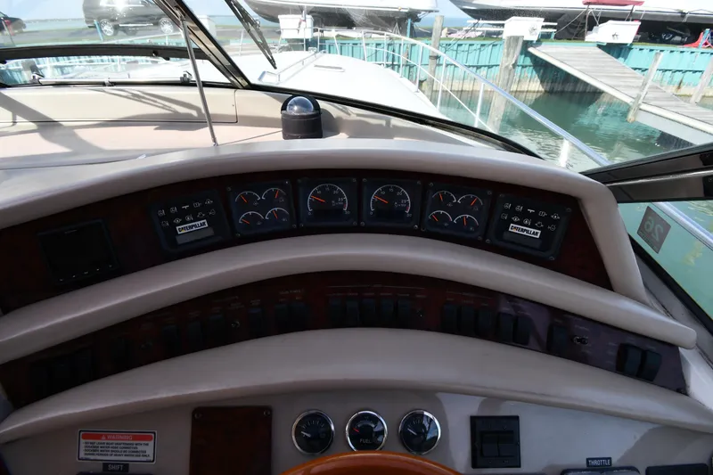 Slide: The Image of 1998 Sea Ray 500 Sundancer dashboard with gauges and controls, docked at marina. - 13