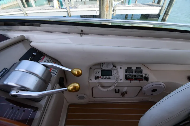 Slide: The Image of Control panel of a 1998 Sea Ray 500 Sundancer yacht, featuring throttle levers and navigation instruments. - 14