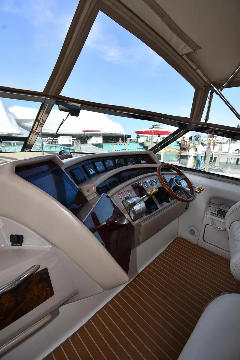 Slide: The Image of 1998 Sea Ray 500 Sundancer helm with modern controls and panoramic marina view. - 16