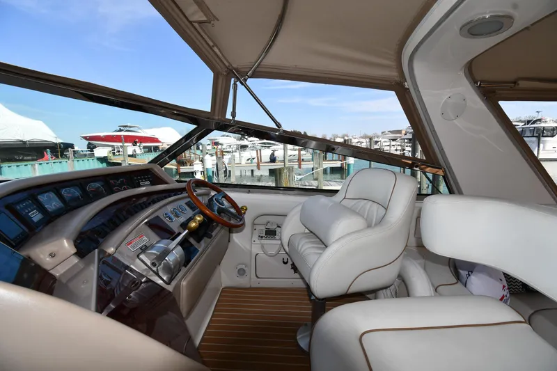 Slide: The Image of 1998 Sea Ray 500 Sundancer cockpit with leather seating and wooden accents at marina. - 17