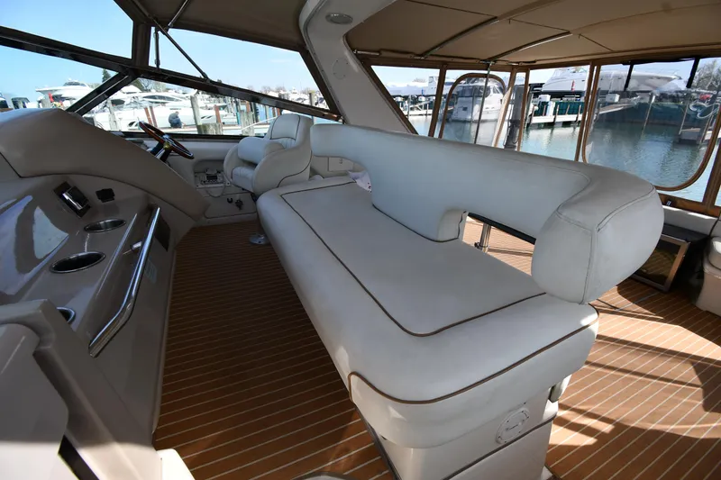 Slide: The Image of 1998 Sea Ray 500 Sundancer interior with beige seating and wooden flooring. - 19