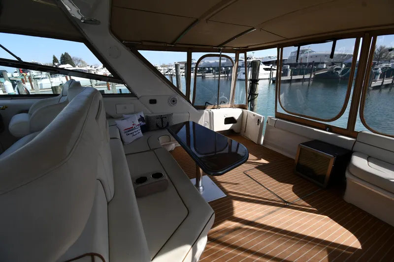 Slide: The Image of 1998 Sea Ray 500 Sundancer interior with seating and table, docked at marina. - 26