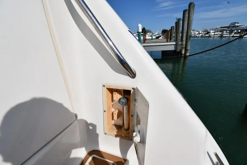 Slide: The Image of 1998 Sea Ray 500 Sundancer boat detail near marina, featuring railing and water view. - 29