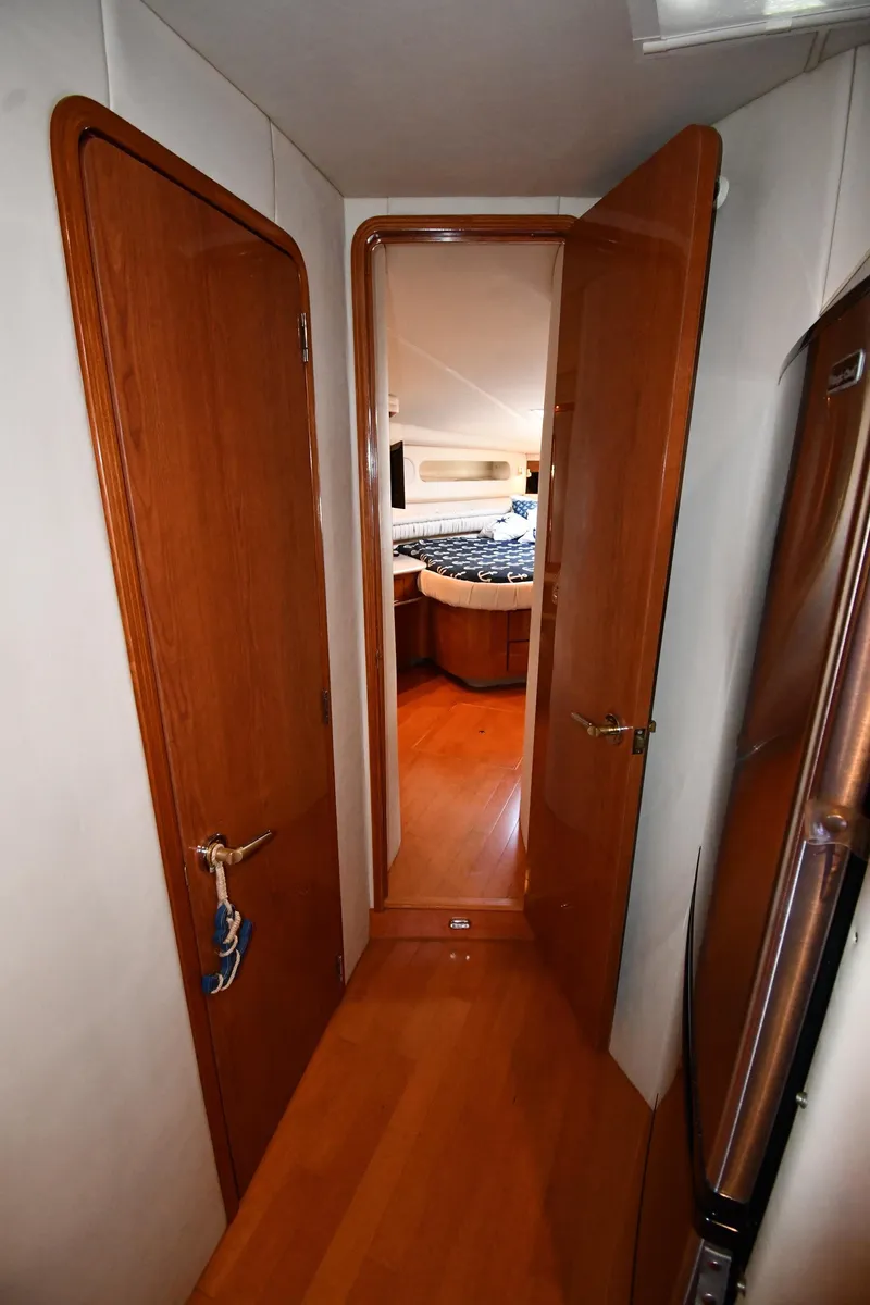 Slide: The Image of Interior hallway of 1998 Sea Ray 500 Sundancer yacht, featuring wooden doors and flooring. - 31