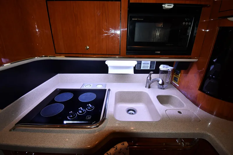 Slide: The Image of Kitchen area of a 1998 Sea Ray 500 Sundancer yacht with stove, sink, and microwave. - 48