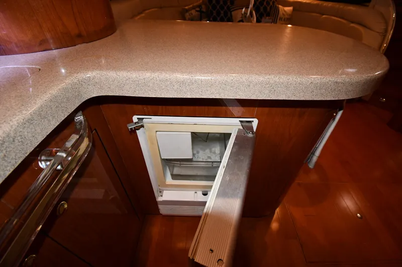 Slide: The Image of 1998 Sea Ray 500 Sundancer interior with open mini fridge under countertop. - 49