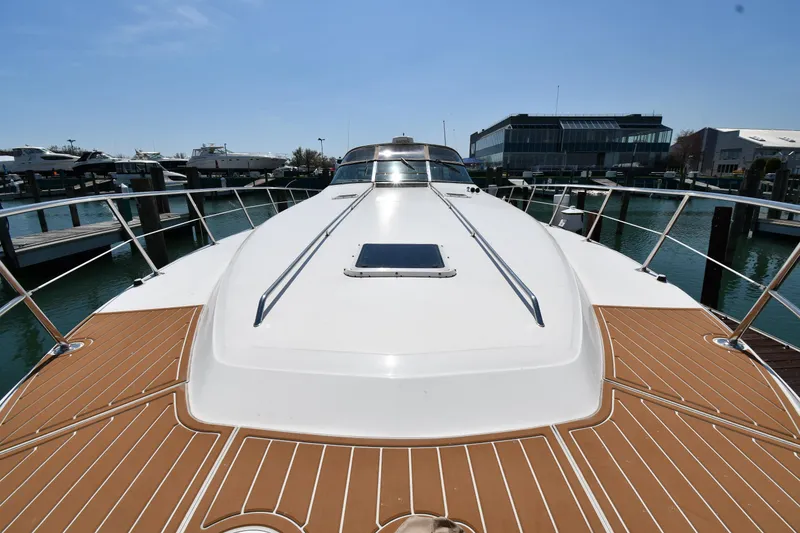 Slide: The Image of 1998 Sea Ray 500 Sundancer yacht docked, showcasing sleek deck design and marina backdrop. - 8