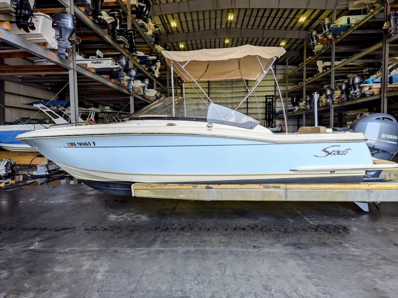 Slide: The Image of 2022 Scout 215 Dorado boat in storage, featuring a sleek design and canopy. - 1
