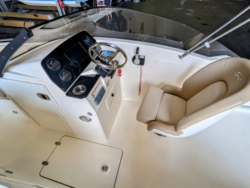 Slide: The Image of 2022 Scout 215 Dorado boat interior with steering wheel and beige seating. - 3