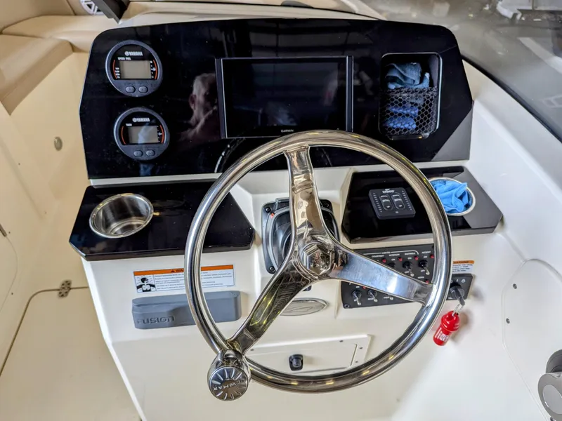 Slide: The Image of 2022 Scout 215 Dorado boat dashboard with steering wheel and control panel. - 6